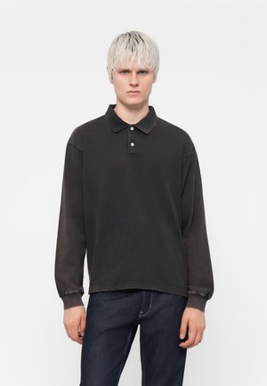 Black long-sleeve polo shirt with a collar, featuring a soft texture and three button placket; worn with dark jeans.