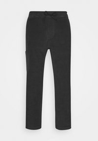 Czarne bawełniane spodnie z elastycznym paskiem, slim fit, z boczną kieszenią i gładką teksturą. Minimalistyczny design bez widocznych wzorów czy akcentów.