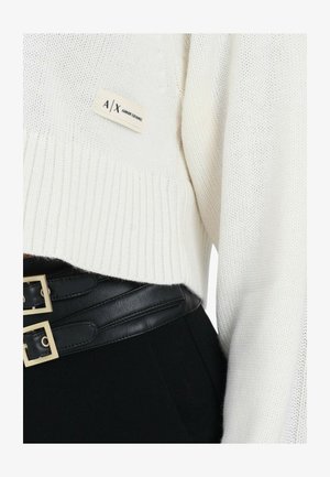 Witte gebreide cropped trui met geribde zoom, voorzien van een A|X Armani Exchange-label. Gecombineerd met een hoge taille zwart tailleceintuur.