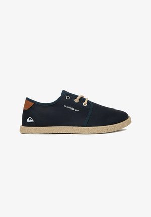 Scarpa casual blu navy con lacci, suola beige, toppa marrone chiaro sul tallone e logo Quiksilver sul lato e sul tallone.