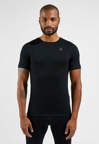 Schwarzes, kurzärmeliges Sportshirt aus glattem Stoff. Merkmale einen runden Ausschnitt und ein minimalistisches Logo auf der oberen linken Seite.