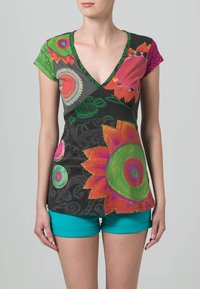 Vícebarevný top s krátkým rukávem a výstřihem do V, zdobený květinovými a kruhovými vzory, černý základ s zelenými akcenty. Kombinován s tyrkysovými šortkami.