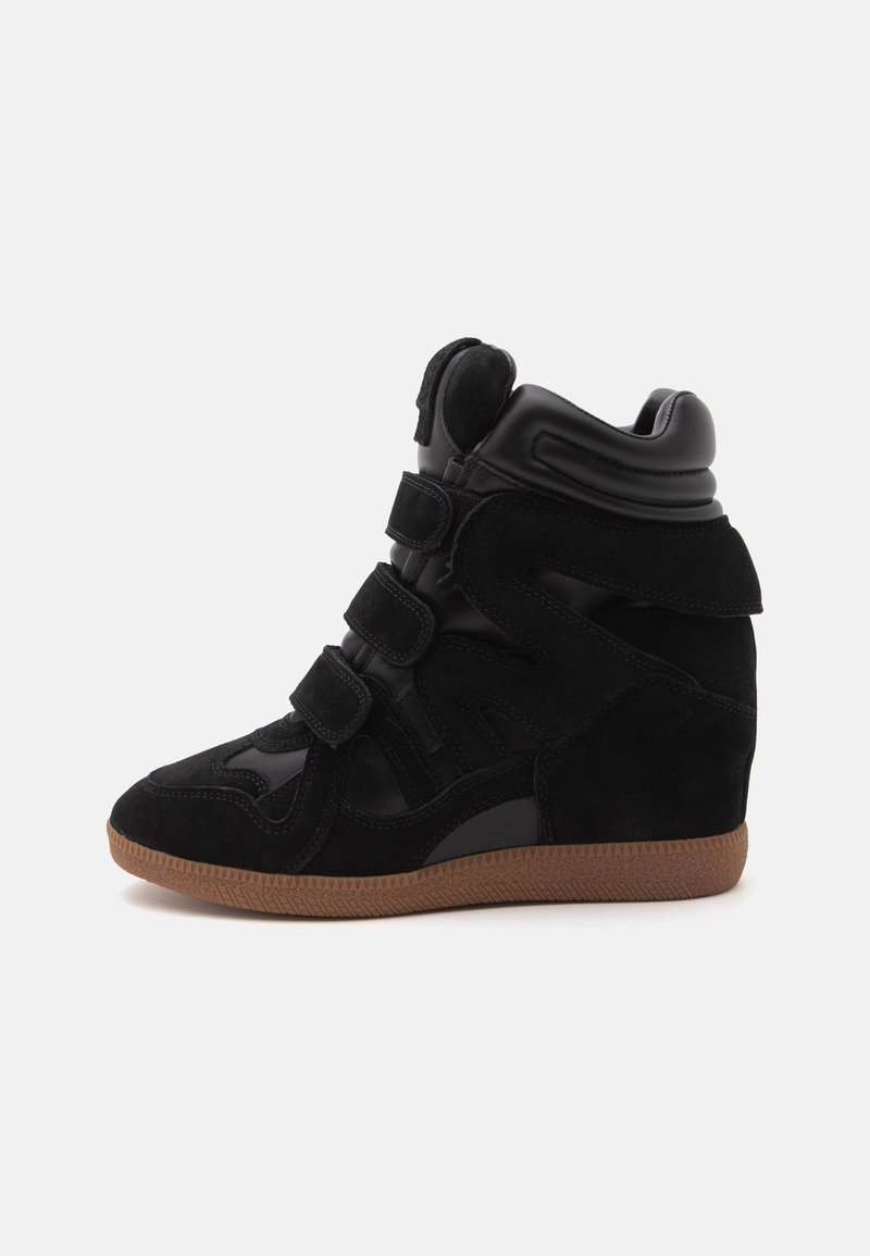Basket montante noire avec trois bandes Velcro, col rembourré et semelle texturée marron, vue de côté sur fond blanc.