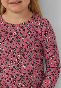 Maglietta a maniche lunghe in tessuto a costine, rosa con motivo floreale nero e blu, scollatura rotonda, superficie testurizzata, adatta per un abbigliamento casual.