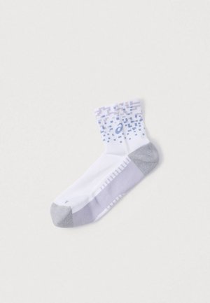 Calzino sportivo bianco con punta e tallone grigi, con polsino decorato in tonalità di viola e blu. Il materiale sembra traspirante ed elastico.