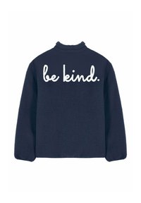 Veste en polaire bleu marine à manches longues avec l'inscription "sois gentil." brodée en grandes lettres blanches sur le haut du dos.