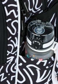 Zaino nero con motivi astratti bianchi; una bottiglia d'acqua grigia con un coperchio trasparente e punti colorati è posizionata nella tasca laterale.