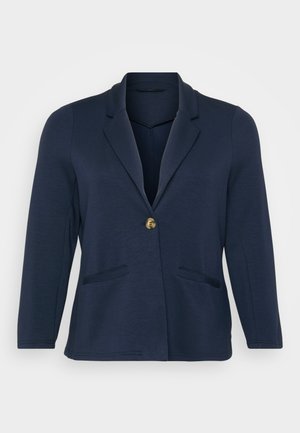 Blazer azul marinho com lapela recortada, fechamento com um único botão dourado e dois bolsos frontais. Tecido suave e macio com um formato estruturado.