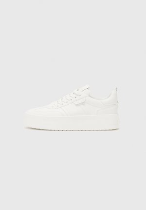 Baskets blanches à plateforme avec lacets à l'avant et col rembourré, vues de profil sur un fond clair uni.
