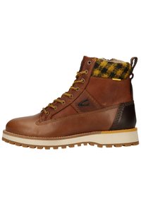 Brown leather hiking boot with yellow laces, plaid collar, durable textured sole, and contrasting black heel detail.