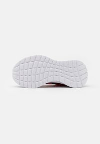 Semelle de chaussure en caoutchouc blanc avec un motif d'adhérence texturé ; dispose d'un design flexible et incurvé pour une traction et une stabilité optimales.