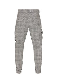 Pantalon cargo à carreaux gris et blanc avec poignets élastiques, poches à rabat à l'arrière et poches cargo latérales, vu de dos.