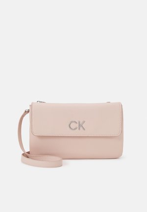 Sac bandoulière rectangulaire rose clair avec fermeture à rabat et logo argenté "CK" sur le devant, doté d'une sangle étroite assortie.