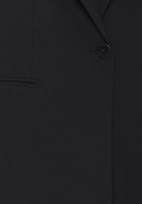 Czarna marynarka z pojedynczym zapięciem na guzik, gładką fakturą, klapami z wycięciem i detalem bocznej kieszeni. Klasyczny i dopasowany fason.