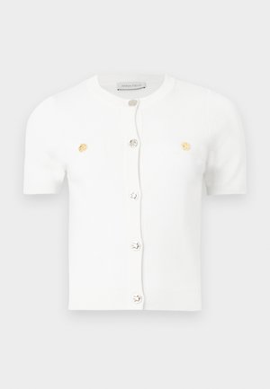 Cardigan blanc à manches courtes avec encolure ronde, boutons argentés et dorés sur le devant, et deux petites poches poitrine.