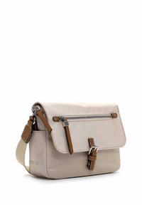 Beige Umhängetasche mit braunem Leder-Reißverschlusszug, Schnallenriemen und verstellbarem beigen Stoff-Schulterriemen vor weißem Hintergrund.