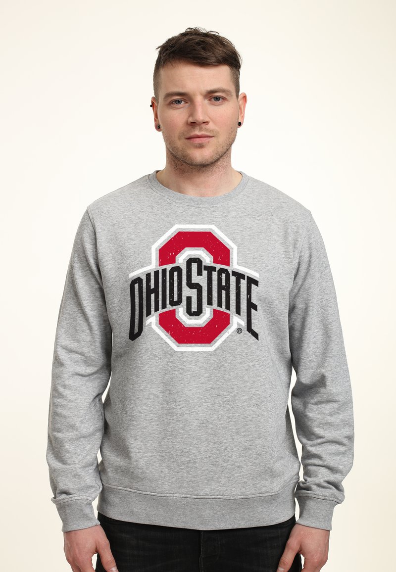 Grijze sweatshirt met een gedurfde "Ohio State" logo in rood en zwart, met geribbelde manchetten en zoom voor structuur en pasvorm. Zachte textuur.