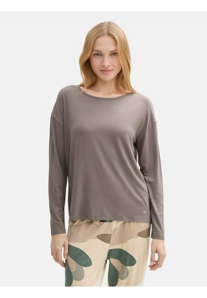 Långärmad, taupe t-shirt med rund halsringning, mjuk textur och avslappnad passform. Matchas med mönstrade, ljusa byxor med gröna accenter.