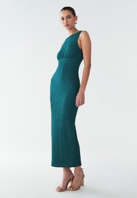Teal, ribbed, ilmanhihaisia mekko, jossa on vyötärölöysä ja suora siluetti, yhdistetty kevyisiin, vaaleisiin, remmisandaleihin.