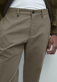 Beige chinos tillverkade av slät tyg, med knappstängning, bältesöglor och sidofickor, med en skräddarsydd passform och minimala sömmar.