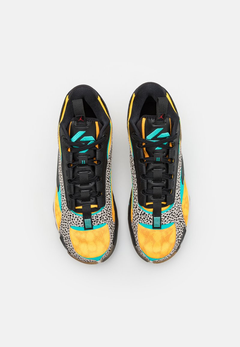 Baskets de sport noires et jaunes avec un imprimé léopard texturé, des accents turquoise et des lacets noirs. Dotées d'un col rembourré et d'une étiquette de logo.