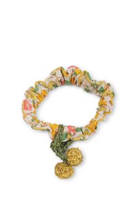 Fascia per capelli con motivo floreale in tessuto bianco, giallo e rosa, con bordi arricciati, dotata di due decorazioni verdi simili a paglia.