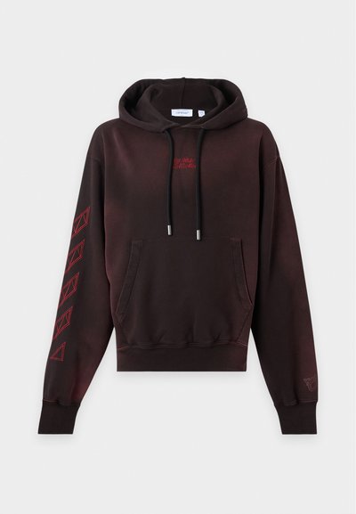 Sweat à capuche marron foncé avec poche avant, cordons noirs, petit texte rouge sur la poitrine et motifs géométriques rouges sur la manche gauche.