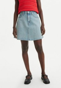 Jupe en denim de forme A de couleur bleu clair, avec un design classique à cinq poches et une taille mi-haute. Texture lisse avec un léger effet délavé.