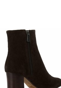 Bottine en daim brun avec une fermeture éclair sur le côté, un talon effilé et une texture lisse. Les détails notables incluent un talon subtilement texturé et un accent métallique.