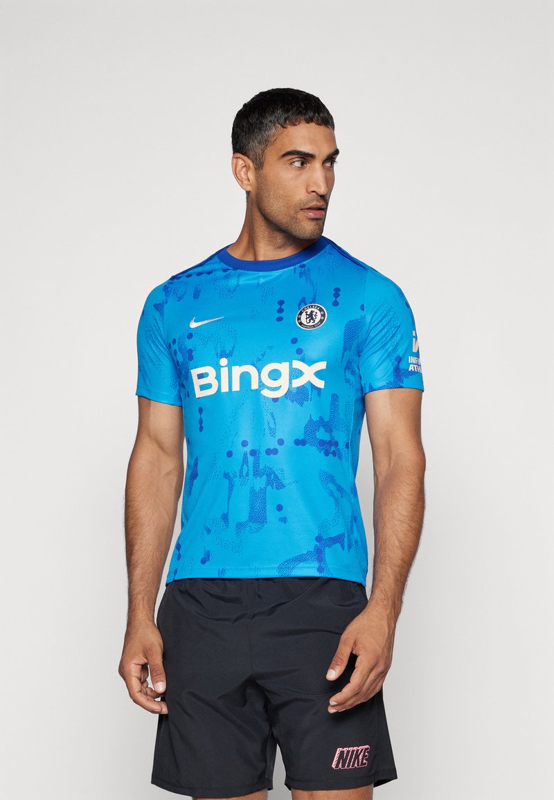 Camisa atlética azul con un patrón abstracto, logo de Nike y la marca "Bingx" en el frente, con un cuello redondo y mangas cortas.