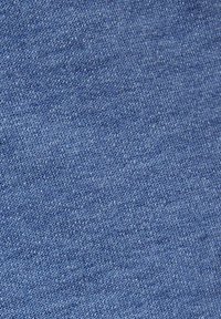 Tessuto di cotone blu con una texture liscia, caratterizzato da un motivo a maglia uniforme e sottili variazioni di tonalità sulla superficie.