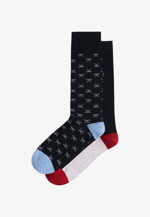 Kniekousen met een zwarte basis en wit schaarpatroon, een lichtblauwe teen, een grijze voetgedeelte en rode hielaccenten.