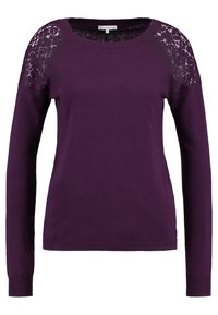 Długi rękaw ciemnofioletowy sweter z koronkowymi detalami kwiatowymi na ramionach oraz prążkowanymi mankietami i dołem.