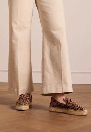 Leopardprint espadrilles met een jute zool, voorzien van bruine veters en een rondneus ontwerp, gecombineerd met beige wijde broek.