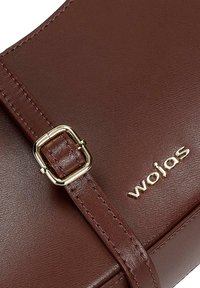 Hnědá kožená kabelka s hladkým povrchem, vybavená čtvercovou zlatě tónovanou sponou a embosovaným logem, podtrhující její elegantní design.