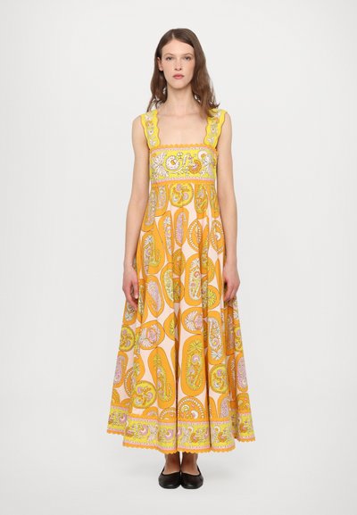 Longue robe jaune avec un corsage ajusté et une jupe évasée, ornée de motifs cachemire en rose et vert, de bretelles festonnées et d'une bordure.