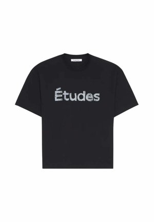 T-shirt noir à manches courtes avec "Études" imprimé en lettres texturées bleu clair sur la poitrine, col rond.