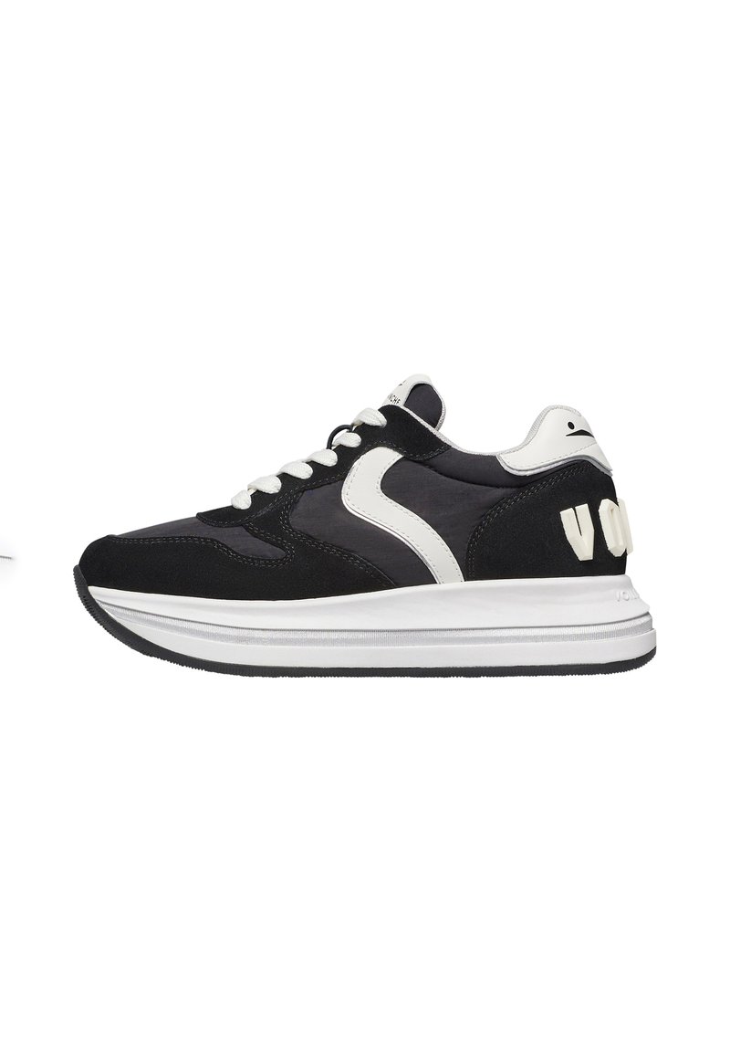 Sneaker in suede nero e tessuto con dettagli bianchi, design con lacci, punta arrotondata e un logo distintivo sul tallone.