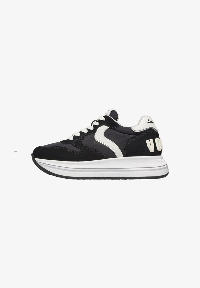 Sneaker in suede nero e tessuto con dettagli bianchi, design con lacci, punta arrotondata e un logo distintivo sul tallone.