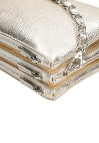 Metaliczna złota torebka kopertowa z teksturowaną powierzchnią, posiadająca trzy zamykane na zamek przegrody oraz srebrny łańcuszek. Zaczepy zamków są spersonalizowane.