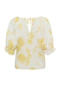 Hvid bluse med gult blomstermønster, der har en V-hals bagtil med snore, puffede ærmer med elastiske manchetter og en afslappet pasform.