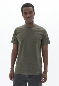 Tricou cu dungi de culoare verde măsliniu, realizat dintr-un material moale, având un guler clasic rotund și mâneci scurte, cu o eticheta pe marginea laterală.