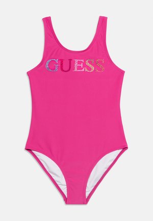 Maillot de bain une pièce rose vif avec logo "GUESS" en strass multicolores sur la poitrine, encolure ronde et bas couvrant entièrement.