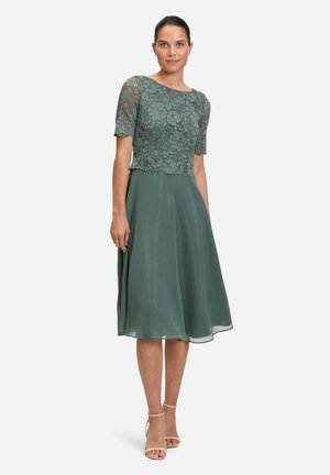 Groene jurk met een kanten lijfje, korte mouwen en een vloeiende chiffon rok, tot de knie, met een zachte textuur en een lichte glans.