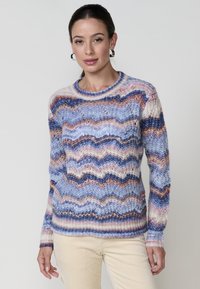 Pull en tricot multicolore présentant un motif ondulé dans des nuances de bleu, rose, crème et marron. Encolure ronde et manches longues.