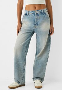 Baggy blauwe denim jeans met een vervaagde afwerking, voorzien van een hoge taille, vijf-pocket ontwerp en zichtbare stikseldetails.