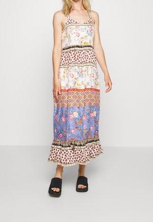 Robe longue avec bretelles tressées, motifs floraux et géométriques en rouge, bleu et blanc, dotée d'un ourlet à volants et d'une coupe à étages.