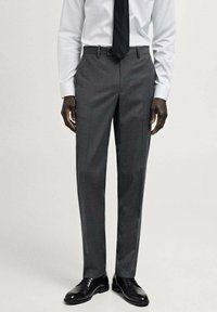 Pantaloni gri din țesătură, cu croi ajustat, având față netedă, buzunare laterale și o siluetă slim, asortați cu pantofi eleganți negri.