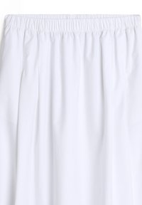 Jupe blanche avec taille élastique, plis doux et texture de tissu lisse.