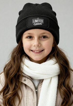 Black knitted beanie featuring a rectangular "LIMITED Edition" label, paired with a white textured scarf, set against a neutral background.